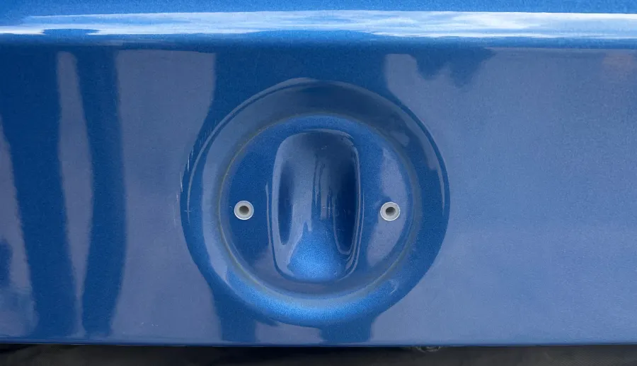 The factory badge recess on a boot lid, with its two existing holes and nothing drilled